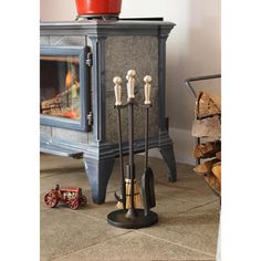 a fireplace with three candles and two brooms on the floor next to it,