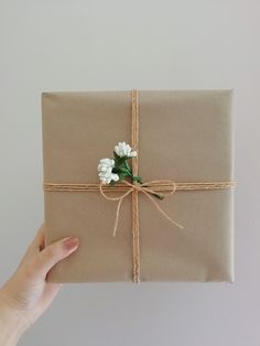 a person holding a wrapped present with flowers on it