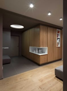 an empty room with wood paneling and white counter tops on the walls, along with wooden flooring