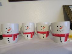 four coffee cups with snowmen painted on them