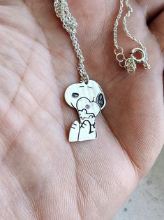 The necklace is a beautiful gift for any occasion to surprise your loved one. Made of high-quality materials and with an embedded spirit, it is a fun and gentle gift for anyone who likes Snoopy's little character. A text or an important date can be written on the back of the figurine. necklace length: 45 cm /  17.72 inches. pendant height: 22mm / 0.87inch. pendant width: 15mm / 0.59inch.  material: silver sample 925 Cute Silver Pendant Charm Necklace, Cute Sterling Silver Pendant Charm Necklaces, Cute Silver Sterling Silver Charm Necklaces, Cute Sterling Silver Pendant Charm Necklace, Cute Charms Jewelry For Gifts, Cute Charms Necklaces As Gift, Cute Charms Necklaces For Gifts, Cute Charms Necklace For Gift, Cute Jewelry For Best Friend Gift