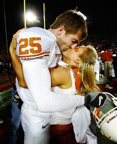 a man and woman kissing on the football field