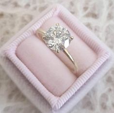 an engagement ring in a pink velvet box