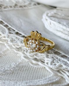 a close up of a ring on top of a white piece of cloth with lace