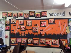 an office decorated with orange and black art work on the wall, along with two desks