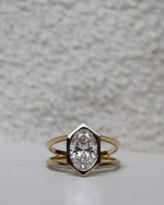 a close up of a ring with a diamond in it on a white tablecloth