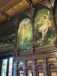 an ornate room with paintings on the walls and wood paneling, along with stained glass windows