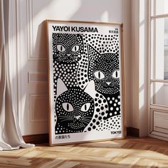 a black and white poster with cats on it in front of a window, next to a wooden floor