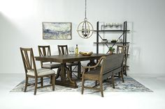 a dinning room table with chairs and a bench in front of it on a rug