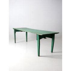 a green table sitting on top of a white floor