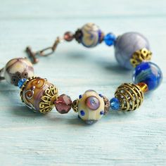 "This Lavender boho bracelet bracelet is a perfect gift for women. It's very tender and unique! This lampwork bracelet fits a 15.5-16.5cm (6.1\"-6.5\" inch) diameter wrist. If you need bigger or smaller size bracelet, please, write me the diameter of your wrist when making an order. Dimentions: 21cm. Materials: artist lampwork beads, metal and glass beads, metal fittings. Colors used: blue, lavender, lilac. Please, note, each lampwork bead is made by hand and may differ slightly. All the photos Bohemian Jewelry With Large Glass Beads, Bohemian Beaded Bracelets With Faceted Beads For Jewelry Making, Handmade Bohemian Glass Bracelets, Handmade Glass Bohemian Bracelets, Bohemian Czech Glass Beads Bracelet, Bohemian Beaded Bracelet With Large Beads As Gift, Bohemian Colorful Glass Beads, Bohemian Crystal Bracelet With Large Beads For Gift, Handmade Bohemian Glass Beaded Bracelets