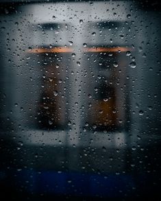 rain drops on a window with a train in the background