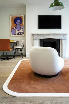 a living room with a large rug on the floor and a tv mounted above it