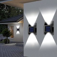 two outdoor lights on the side of a house