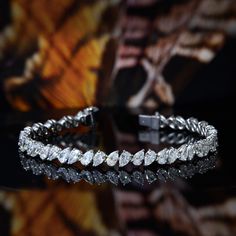 This 9.00 carat brilliant pear cut diamond tennis bracelet have a remarkable 100% eye-clean VS2 clarity grading and G color grading (very white) where these diamond stones glitters and sparkles perfectly. It is a magnificent prong setting that stretches to 7.5 inches long (other length available by request). Metal : 14K Gold or 18K Gold Setting Type : Prong Total Carat Weight : 9.00 Carats Type : Natural Shape : Pear Cut Carat Weight : 9.00 Ct. Cut : Excellent Color : G (White) Clarity : VS2 (10 Pear Shape Diamond Bracelet, Unique Gold Jewelry Designs, Bracelet Diamond, Diamond Jewelry Necklace, Pear Cut Diamond, Diamond Tennis Bracelet, Diamond Bangle, Color Grading, Pear Shaped Diamond