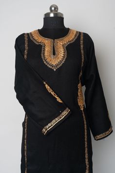 Discover the timeless charm of our Ebony Elegance Kashmiri Pheran, adorned with exquisite Tilla embroidery. This stunning dress features a deep black base, beautifully enhanced with intricate gold Tilla embroidery that creates a striking contrast. The detailed neckline and sleeves add a touch of regal sophistication, making this dress perfect for festive celebrations and elegant gatherings. Designed for the discerning woman who values tradition and contemporary fashion, this Kashmiri Pheran offe Black Traditional Drape Kaftan For Festive Occasions, Festive Gold Kurta With Floral Embroidery, Bollywood Style Gold Kurta With Embroidered Border, Black Ceremonial Kaftan For Eid, Gold Bollywood Kurta With Embroidered Border, Black Kaftan With Resham Embroidery Traditional Drape, Elegant Kurta With Embroidered Border For Festivals, Bollywood Style Black Embroidered Fabric, Black Bollywood Embroidered Fabric With Border