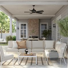 a white couch sitting on top of a wooden floor next to a table and chairs