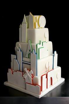 a multi - tiered cake with white frosting and colorful icing on top