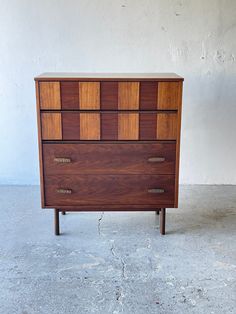 a wooden dresser sitting on top of a cement floor