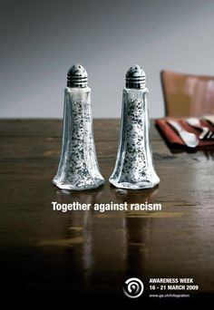 two salt and pepper shakers sitting on top of a wooden table