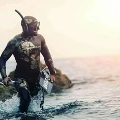 a man in a wet suit walking into the ocean