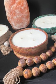 some candles are sitting on a table next to other decorations and beads, including an orange stone