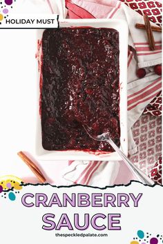 cranberry sauce in a square white dish on a red and white tablecloth