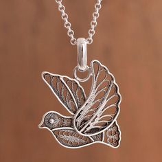 Peruvian artisan Nancy Quispe designs and handcrafts this beautiful pendant necklace of a dove inspired by its messages of peace faith and hope. The sterling silver dove is created with the filigree technique with graceful loops and swirls of ribbons of sterling silver forming the dove's feathers accentuated by a striking combination of finishes. Sterling Silver Bird Pendant Jewelry, Handmade Sterling Silver Bird-shaped Jewelry, Filigree Silver Jewelry, Dove Necklace, Filigree Pendant Necklace, Beautiful Pendant Necklace, Styles Hairstyles, Faith And Hope, Filigree Necklaces