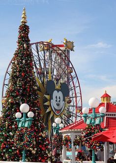 the mickey mouse christmas tree is in front of an amusement park