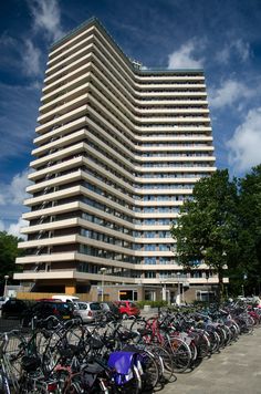 many bicycles are parked in front of a tall building