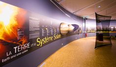 a large wall with pictures on it in an office building at night time, showing the solar system and its satellites