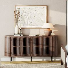 a living room with a couch, lamp and art on the wall above it's sideboard