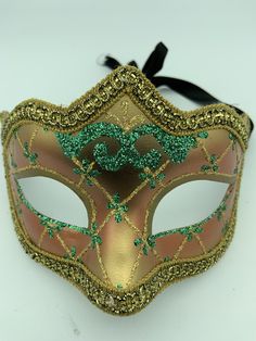 "This is a very nice original handmade and hand painted Venezia masquerade face mask made in Italy. The design on the shiny gold and orange face mask features turquoise blue and multi-color glitter with a border of gold lace and gold rope around the edges. It comes with a black ribbon tie and is stamped on the back \"Original Hand Painted Made in Italy Venezia\". The mask measures approximately 6 5/8\" long and 3 3/4\" wide and is in very good preowned condition with light wear on the back of th Artistic Masks For Carnival Costume Party, Artistic Masks For Costume Party And Carnival, Venetian Masks For Carnival And Festivals, Multicolor Halloween Masquerade Masks And Prosthetics, Multicolor Masks And Prosthetics For Halloween Masquerade, Venetian Mask For Mardi Gras Costume, Venetian Masks For Mardi Gras Costume Party, Venetian Masks For Mardi Gras, Venetian Masks For Mardi Gras Carnival