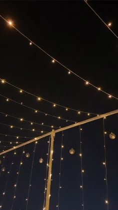 string lights hang from the ceiling in front of a dark sky with no one on it