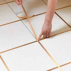 a person measuring the width of a tile floor