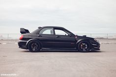 a black car parked on top of a parking lot