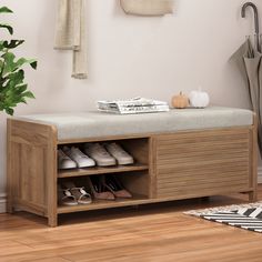 a wooden bench with shoes on it in front of a white wall and potted plant