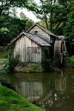 an old water mill is surrounded by greenery