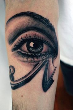 an eye tattoo on the arm with scissors in its irise and ribbon around it