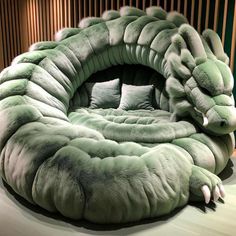 an animal bed is made to look like it has been curled up in the shape of a dragon