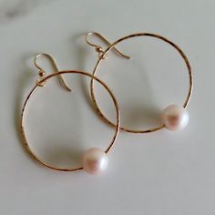 Gold Hoop Pearl Earrings~ These elegant gold hoop earrings have freshwater white pearls with a hint of light pink, will look great for any occasion. Hammered and polished to a beautiful shine. Hoops are approx. 1.5" *Model wearing similar design~ https://www.etsy.com/listing/111095394/white-pearl-earrings-gold-hammered-hoops?ref=shop_home_active_22 Shop~ http://www.etsy.com/shop/HanaMauiCreations?ref=pr_shop_more International buyers please read our shipping policies before ordering~ POLICIES~ https://www.etsy.com/shop/HanaMauiCreations/policy?ref=shopinfo_policies_leftnav Everyday Round Pearl Chain Earrings, Minimalist Round Pearl Drop Bridal Earrings, Hoop Pearl Drop Jewelry For Gifts, Pearl Drop Hoop Jewelry Gift, Pearl Drop Hoop Earrings As Gift, Delicate Small Hoop Jewelry With Pearl Charm, Rose Gold Hoop Earrings With Pearl Drop For Wedding, Rose Gold Pearl Drop Hoop Earrings For Wedding, Hypoallergenic Rose Gold Round Pearl Earrings