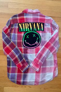 One-of-a-kind Flannel featuring the legendary, one and only, Nirvana! Thrifted and Prewashed 100% cotton button-up with a t-shirt print stitched to the back.   Size Large  Measurements: ♥  Shoulders: 19.25" ♥  Chest: 24" ♥  Sleeve: 25.25" ♥  Length: 26" . . . . . . . . . . . . . . . . . . . . . . . . . . . . . . . . . . . . . . . . . . . . . Handmade ♥ Thrifted ♥ Recycled ♥ Upcycled These button-ups are created with a thrifted button-up and shirts that need a second life and once they are combin Vintage Cotton Flannel Shirt For Streetwear, Fall Cotton Shirt With Patchwork, Fall Festival Cotton Shirt, Cotton Festival Shirt For Fall, Trendy Plaid Cotton Flannel Shirt, Cotton Patchwork Shirt For Streetwear, Hippie Cotton Tops For Streetwear, Trendy Relaxed Fit Cotton Flannel Shirt, Cotton Patchwork Button-up Flannel Shirt