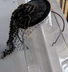 This Black and Gold Beaded Flower Sinamay Fascinator Hat with Veil and Satin Headband is a beautiful accessory for weddings, parties, cocktail, evening, and other special occasions. It is elegant, sparkling, stylish, and super chic! The perfect Fall/Winter piece that will definitely add a special touch to your outfit!! ** Black Sinamay Base is 10 cm. I only accept PayPal and ship all orders within 24 hours via USPS. Feel free to send me a convo with any questions. Thank you for visiting Hettie Hair Accessories! Evening Headpiece With Pinched Crown For Kentucky Derby, Evening Pinched Crown Headpiece For Kentucky Derby, Elegant Bead Cap Headband, Adjustable Gatsby Evening Headpiece, Adjustable Gatsby Style Costume Hats For Evening, Elegant Evening Headpiece With Structured Crown, Adjustable Gatsby Style Evening Costume Hat, Adjustable Fascinator With Structured Crown For Party, Handmade Pinched Crown Headpiece For Party