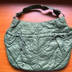 Women's Green Hobo Bag. Quilted Nylon With Two Front Pockets Adjustable With Cotton Cord Ties. Interior Fully Lined With Zippered Pocket. Small Nick On Handle As Shown In Photo. New Never Worn. Casual Nylon Hobo Bag For Travel, Casual Large Capacity Nylon Diaper Bag, Large Capacity Nylon Diaper Bag, Casual Nylon Diaper Bag With Large Capacity, Casual Nylon Diaper Bag For Daily Use, Casual Quilted Hobo Bag For Everyday, Casual Quilted Hobo Bag, Casual Nylon Diaper Bag For Everyday Use, Casual Nylon Hobo Tote Bag