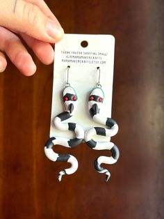 These adorably spooky sandworm earrings are each made completely by hand, so no 2 are exact replicas! The perfect gift for the Beetlejuice lover in your life.  3.5" in length. Handmade polymer clay earrings.  Stainless steel findings with silicone backs.  Arrives in giftable bag.  Store the earrings with care; if bent or crushed they may break.  Thank you for your support! Quirky Handmade Halloween Jewelry, Beetlejuice Earrings, Earrings Snake, Earrings Halloween, Snake Earrings, Halloween Earrings, Beetlejuice, Handmade Polymer Clay, Polymer Clay Earrings