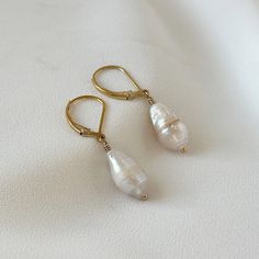 "Introducing Baroque Pearl Earrings in a mesmerizing combination of gold and fresh water pearls. These dangle drop earrings are perfect for the modern woman who loves a touch of elegance in her minimalist style. The beautiful Baroque pearls gracefully dangle from the gold hooks, creating a chic and timeless accessory. Ideal for anniversary celebrations, weddings, or any special occasion, these earrings will make a stunning statement. Give the gift of refined beauty with these Baroque Pearl Minim 14k Gold Filled Pearl White Dangle Pearl Earrings, 14k Gold Filled Pearl Drop Earrings For Anniversary, Dainty Pearl White 14k Gold Filled Pearl Earrings, 14k Gold-filled Pear-shaped Pearl Drop Jewelry, 14k Gold-filled Pearl White Earrings With Pearl Charm, Pearl White Earrings With Pearl Charm In 14k Gold, Wedding Pearl Earrings With 14k Gold Filled Ear Wire, Elegant Drop Pearl Earrings In 14k Gold Filled, Minimalist White Pearl Earrings 14k Gold Filled