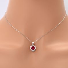 Lab Grown Ruby Heart Necklace For Women Discover our minimalist dainty necklace featuring a 7x7 mm heart shaped Ruby in the center accented with 28 pieces of round cut moissanite stones of 1.4 mm around the main stone creating a halo necklace design. This love necklace is carefully set in Rhodium over 925 Sterling Silver weighing a total of 1.63 ct. The beautiful design of this heart pendant makes a great gift for woman that she can adore around her neck. Love Necklace Halo Ruby Pendant Gift This created ruby heart pendant is a great way to express your love. Halo pendants are not just any regular pendants, they have a deeper meaning attached to them making them a special gift for her. The halo represents the embrace of your affection, enveloping your partner's neck with a dazzling display Cubic Zirconia Heart Necklace With Gemstone For Valentine's Day, Heart Necklace With Cubic Zirconia For Valentine's Day, Valentine's Day Heart Necklace With Cubic Zirconia Gemstone, Heart Cut Diamond Accents Necklace For Her, Cubic Zirconia Heart Necklace With Gemstone, Cubic Zirconia Heart Cut Birthstone Necklaces, Heart Cut Diamond Accents Necklace For Valentine's Day, Heart Cut Cubic Zirconia Necklace As Gift For Her, Heart Cut Birthstone Necklace In Cubic Zirconia