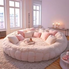 a living room filled with lots of furniture and pillows on top of a white rug