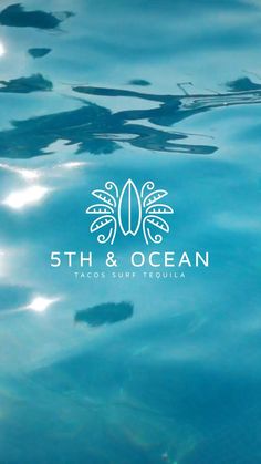 the logo for an ocean restaurant is reflected in the blue water, with sun reflecting on the surface