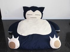 a large stuffed animal sitting on top of a black floor next to a white wall